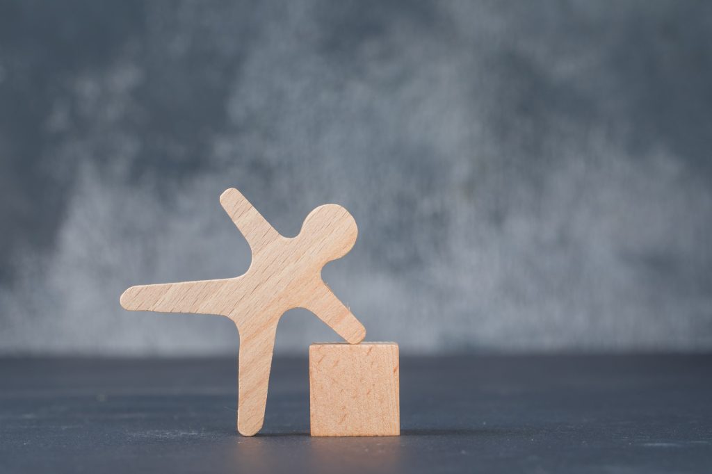 conceptual-business-with-wooden-block-with-wooden-human-figure